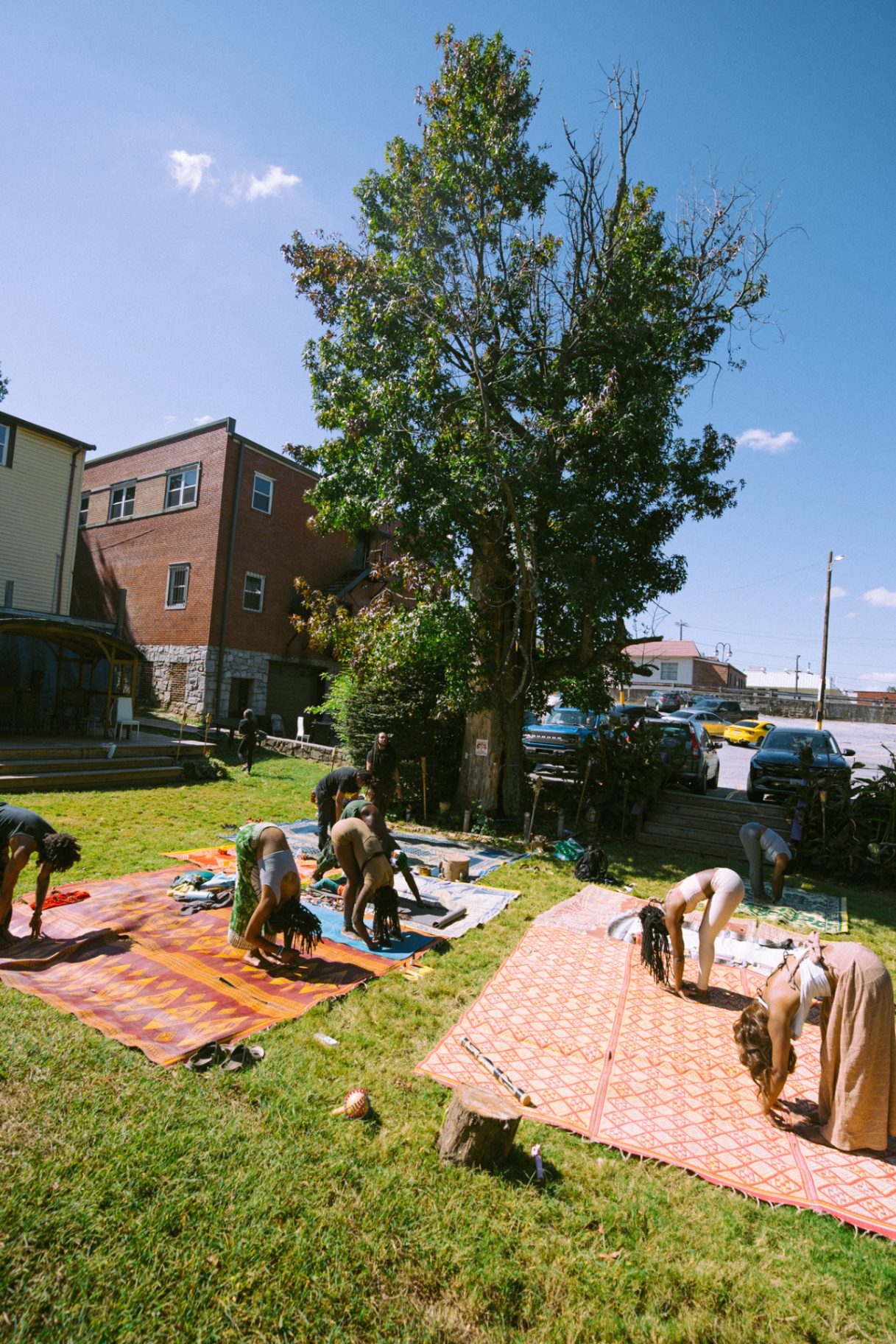 Community guided yoga sequence on woven mats at Tassili's Raw Reality in Atlanta